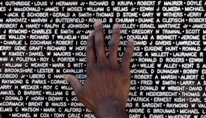 The hand of a visitor to the Vietnam Traveling Memorial Wall reaches out to touch the name of a family member who had died in the Vietnam War. AP Photo/Phil Coale