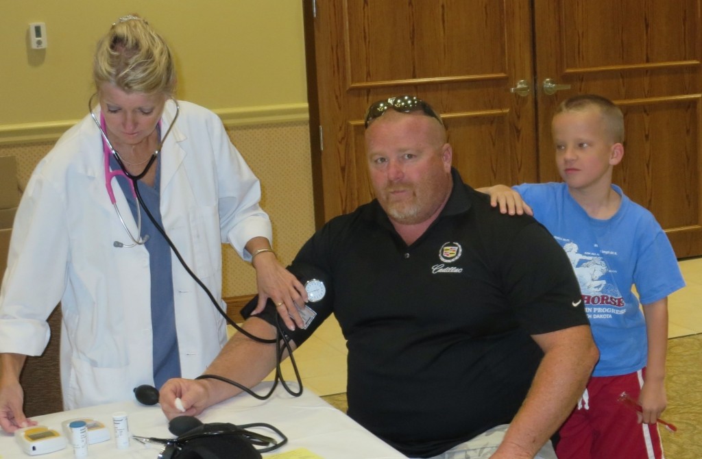 UNDER PRESSURE: Local 110 offered free blood pressure screenings for members in attendance at its annual Backpack Drive, Aug. 9. This little guy apparently wanted to make sure Dad got checked out. – Laborers Local 110 photos 