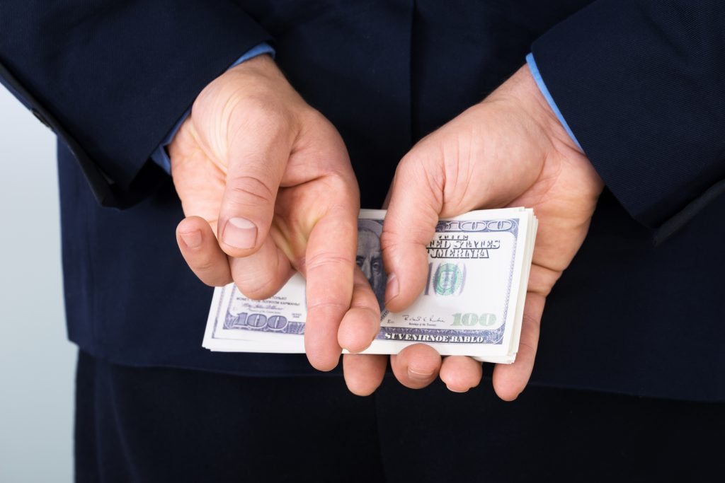 Businessman With Finger Crossed Holding Banknotes