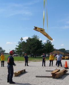 INSTRUCTOR BRIAN GRAFF’S GROUP watches while the crane operator hoists the metal piece into the air. – Labor Tribune photo